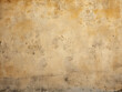 Close-up of a plastered wall reveals a fine, grungy texture with golden hues