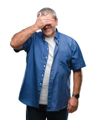 Sticker - Handsome senior man over isolated background smiling and laughing with hand on face covering eyes for surprise. Blind concept.