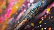 Extreme close-up of a paintbrush handle covered in colorful splatters, evidence of a creative process.