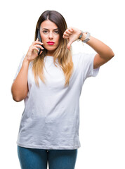 Wall Mural - Young beautiful woman speaking calling using smartphone over isolated background with angry face, negative sign showing dislike with thumbs down, rejection concept