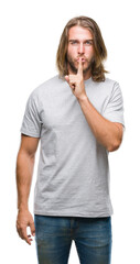 Canvas Print - Young handsome man with long hair over isolated background asking to be quiet with finger on lips. Silence and secret concept.