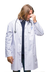 Canvas Print - Young handsome doctor man with long hair over isolated background tired rubbing nose and eyes feeling fatigue and headache. Stress and frustration concept.