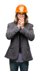 Poster - Young handsome architec man with long hair wearing safety helmet over isolated background shocked covering mouth with hands for mistake. Secret concept.