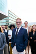 Vertical cheerful smiling team of diverse business people in formal suit looking confident camera with positive faces gathered outside the work building. Happy corporate work team posing for portrait