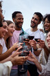 © CarlosBarquero - Vertical. Gathering of diverse cheerful friends toasting red wine and celebrating birthday party event outdoor. Young laughing people together enjoying free time on weekend