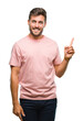 © Krakenimages.com - Young handsome man over isolated background with a big smile on face, pointing with hand and finger to the side looking at the camera.
