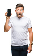 Poster - Young handsome man showing smartphone screen over isolated background scared in shock with a surprise face, afraid and excited with fear expression