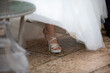 bride's elegant white wedding shoes peeking from under gown