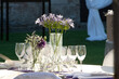elegant table setting with purple floral centerpiece for an outdoor event