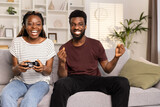 Fototapeta Zachód słońca - Couple Enjoying Video Games On Couch At Home, Lifestyle And Entertainment Concept, Leisure Time, Happy, Together, Fun