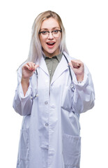 Canvas Print - Young blonde doctor woman over isolated background looking confident with smile on face, pointing oneself with fingers proud and happy.