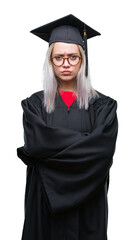 Canvas Print - Young blonde woman wearing graduate uniform over isolated background skeptic and nervous, disapproving expression on face with crossed arms. Negative person.