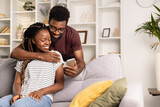Fototapeta Panele - Happy Couple Relaxing On Sofa At Home With Smartphone, Casual Lifestyle, Modern Living Room Interior