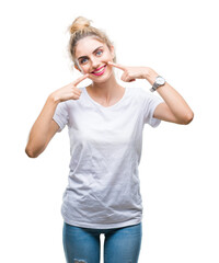 Sticker - Young beautiful blonde woman wearing white t-shirt over isolated background smiling confident showing and pointing with fingers teeth and mouth. Health concept.