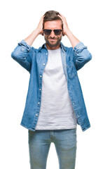 Wall Mural - Young handsome man wearing sunglasses over isolated background suffering from headache desperate and stressed because pain and migraine. Hands on head.
