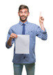 © Krakenimages.com - Young handsome man holding blank paper over isolated background surprised with an idea or question pointing finger with happy face, number one