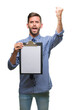 © Krakenimages.com - Young handsome business man holding clipboard over isolated background annoyed and frustrated shouting with anger, crazy and yelling with raised hand, anger concept
