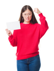 Wall Mural - Young Chinese woman over isolated background holding blank card annoyed and frustrated shouting with anger, crazy and yelling with raised hand, anger concept