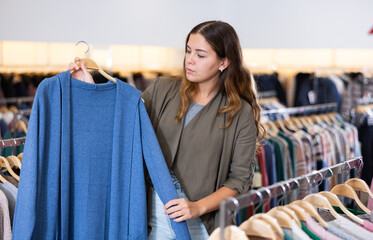 Canvas Print - Casual young woman chooses summer clothes in a clothing store