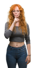 Poster - Young redhead woman asking to be quiet with finger on lips. Silence and secret concept.