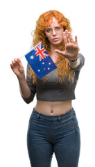 Sticker - Young redhead woman holding flag of Australia with open hand doing stop sign with serious and confident expression, defense gesture