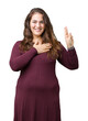 Beautiful and attractive plus size young woman wearing a dress over isolated background Swearing with hand on chest and fingers, making a loyalty promise oath