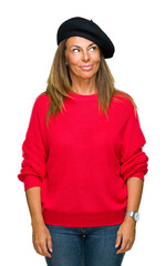 Wall Mural - Middle age adult woman wearing fashion beret over isolated background smiling looking side and staring away thinking.