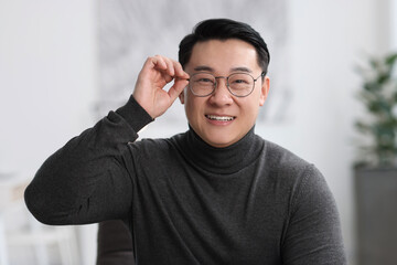 Wall Mural - Portrait of smiling businessman in glasses indoors