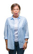© Krakenimages.com - Middle age senior hispanic woman over isolated background afraid and shocked with surprise expression, fear and excited face.