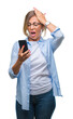 © Krakenimages.com - Middle age senior woman texting sending message using smartphone over isolated background stressed with hand on head, shocked with shame and surprise face, angry and frustrated. Fear and upset.