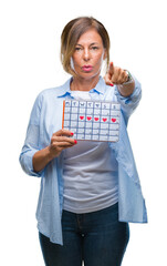 Wall Mural - Middle age senior hispanic woman holding menstruation calendar over isolated background pointing with finger to the camera and to you, hand sign, positive and confident gesture from the front