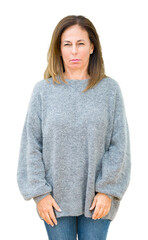 Wall Mural - beautiful middle age woman wearing winter sweater over isolated background skeptic and nervous, frow
