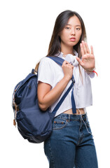 Sticker - Young asian woman wearing backpack and headphones over isolated background with open hand doing stop sign with serious and confident expression, defense gesture