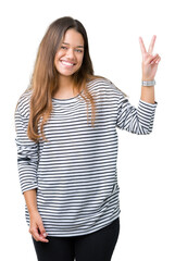 Sticker - Young beautiful brunette woman wearing stripes sweater over isolated background smiling with happy face winking at the camera doing victory sign. Number two.