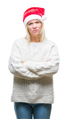 Wall Mural - Young beautiful blonde woman wearing christmas hat over isolated background skeptic and nervous, disapproving expression on face with crossed arms. Negative person.