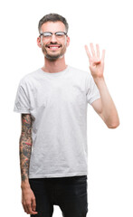 Sticker - Young tattooed adult man showing and pointing up with fingers number four while smiling confident and happy.