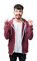 Sticker - Young handsome man over isolated background excited for success with arms raised celebrating victory smiling. Winner concept.