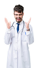 Wall Mural - Young doctor man wearing hospital coat over isolated background celebrating mad and crazy for success with arms raised and closed eyes screaming excited. Winner concept