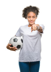 Wall Mural - Young beautiful afro american holding soccer football ball over isolated background pointing with finger to the camera and to you, hand sign, positive and confident gesture from the front