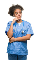 Sticker - Young afro american doctor woman over isolated background with hand on chin thinking about question, pensive expression. Smiling with thoughtful face. Doubt concept.