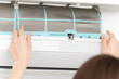 エアコンのフィルターを掃除する若い女性　ライフスタイルイメージ