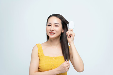 Wall Mural - Portrait of smiling asian woman brushing her hair