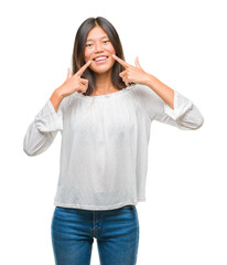 Sticker - Young asian woman over isolated background smiling confident showing and pointing with fingers teeth and mouth. Health concept.