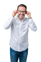 Wall Mural - Handsome middle age elegant senior business man wearing glasses over isolated background Smiling pulling ears with fingers, funny gesture. Audition problem