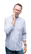 © Krakenimages.com - Middle age hoary senior man wearing glasses over isolated background touching mouth with hand with painful expression because of toothache or dental illness on teeth. Dentist concept.