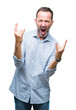 © Krakenimages.com - Middle age hoary senior business man over isolated background shouting with crazy expression doing rock symbol with hands up. Music star. Heavy concept.