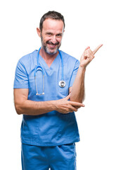 Canvas Print - Middle age hoary senior doctor man wearing medical uniform over isolated background with a big smile on face, pointing with hand and finger to the side looking at the camera.