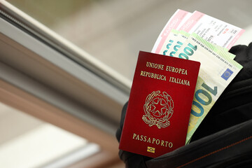 Wall Mural - Italian passport and euro money bills with airline tickets on backpack close up