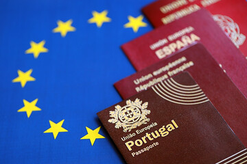 Wall Mural - European union countries passports on blue EU flag close up. Portugal, Spanish, French and Italian passports