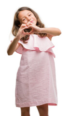 Poster - Brunette hispanic girl wearing pink dress smiling in love showing heart symbol and shape with hands. Romantic concept.